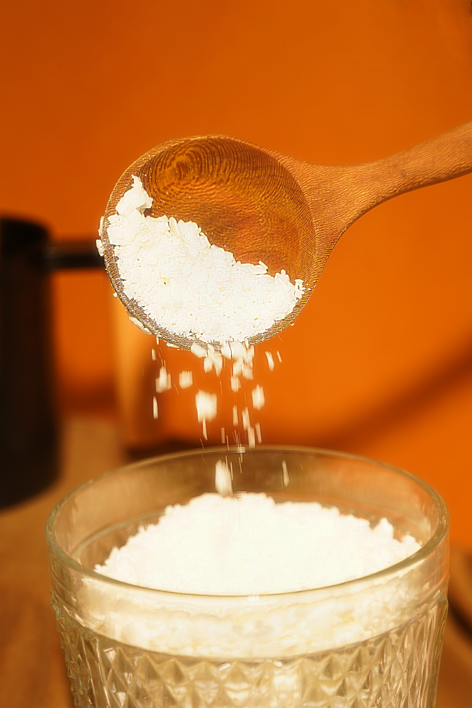 Hand pouring soy wax into candle jars during small batch candle making with beeswax blend for clean, natural burn.