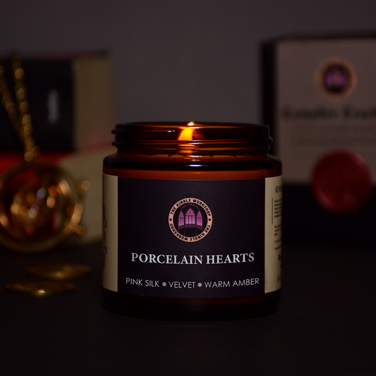 Candle in an amber jar labeled 'Porcelain Hearts' with a dark background