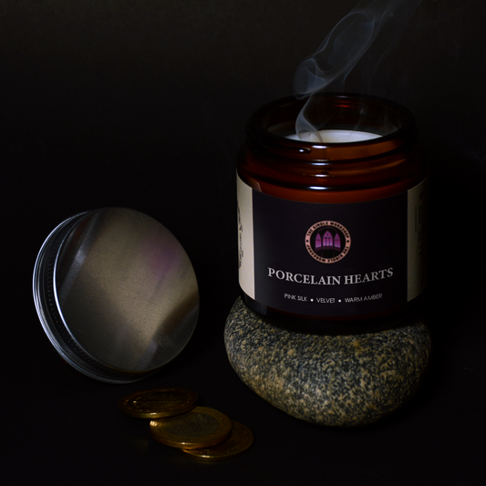 Candle jar labeled 'Porcelain Hearts' with smoke on a dark background